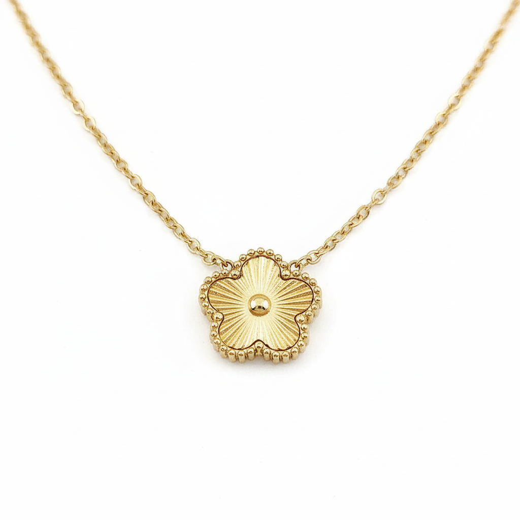 Gold textured clover necklace on white background